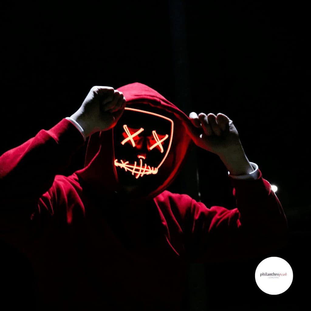 Person wearing glowing mask in dark setting.