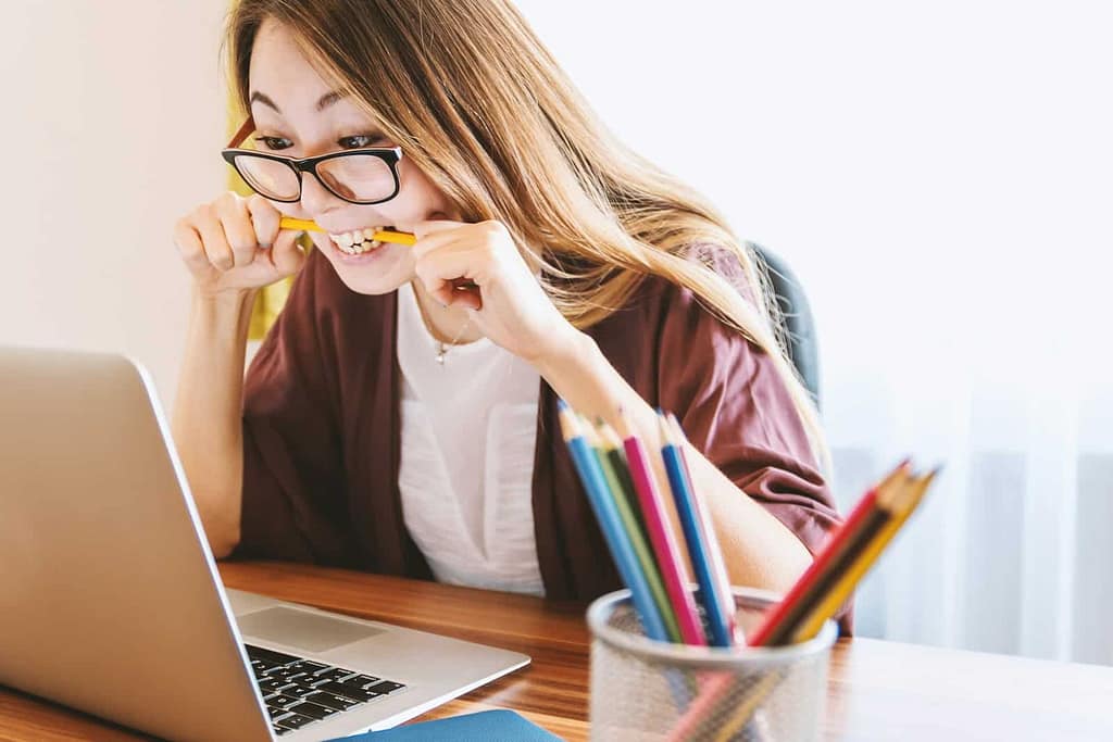 - Philanthropeak Coaching woman biting pencil while sitting on chair in front of computer during daytime . how to focus with adhd