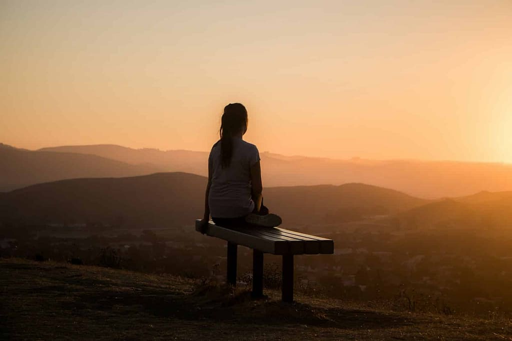 - Philanthropeak Coaching woman sitting on bench over viewing mountain ADHD Meltdown