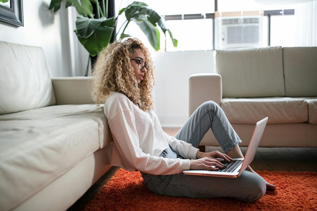 woman sitting on floor and leaning on couch using laptop Low Functioning Autism