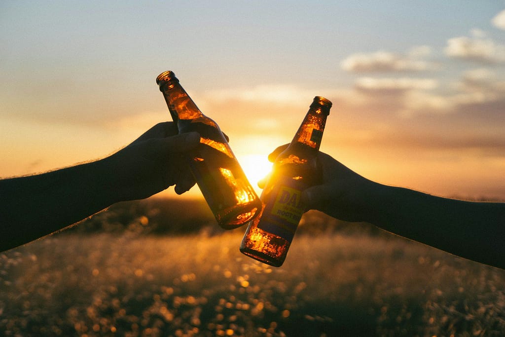 photography of person holding glass bottles during sunset ADHD and Alcohol