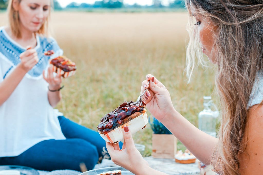 two people eating cake on blue blanket - ADHD Eating Habits