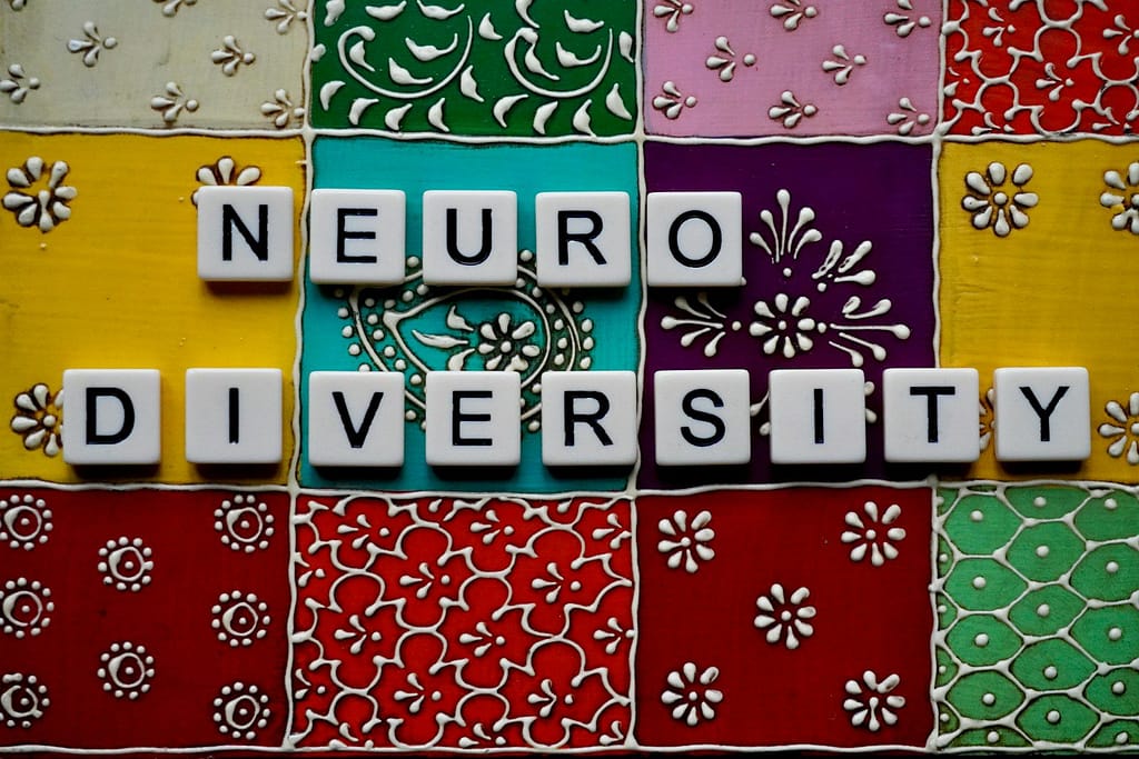 the word neuro university spelled with scrabble tiles neurodivergent business coaching