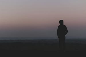 Silhouette of person standing at dusk landscape - Philanthropeak Coaching silhouette of man standing on hill during sunset ADHD Brain Fog