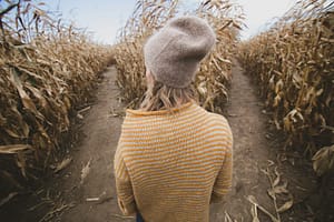 woman standing in brown field while looking sideways - adhd and decision making