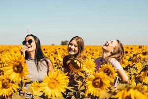 woman in white and black striped shirt standing on yellow sunflower field during daytime - ADHD and Friendships
