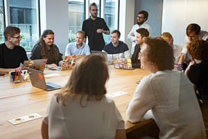 Photo by Redmind Studio - Philanthropeak Coaching a group of people sitting around a wooden table adhd business coaching