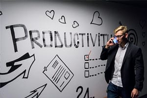 Photo by Andreas Klassen - Philanthropeak Coaching man holding smartphone looking at productivity wall decor adhd productivity business owners