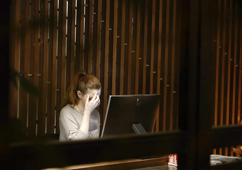 a woman sitting in front of a laptop computer. ADHD Burnout Recovery